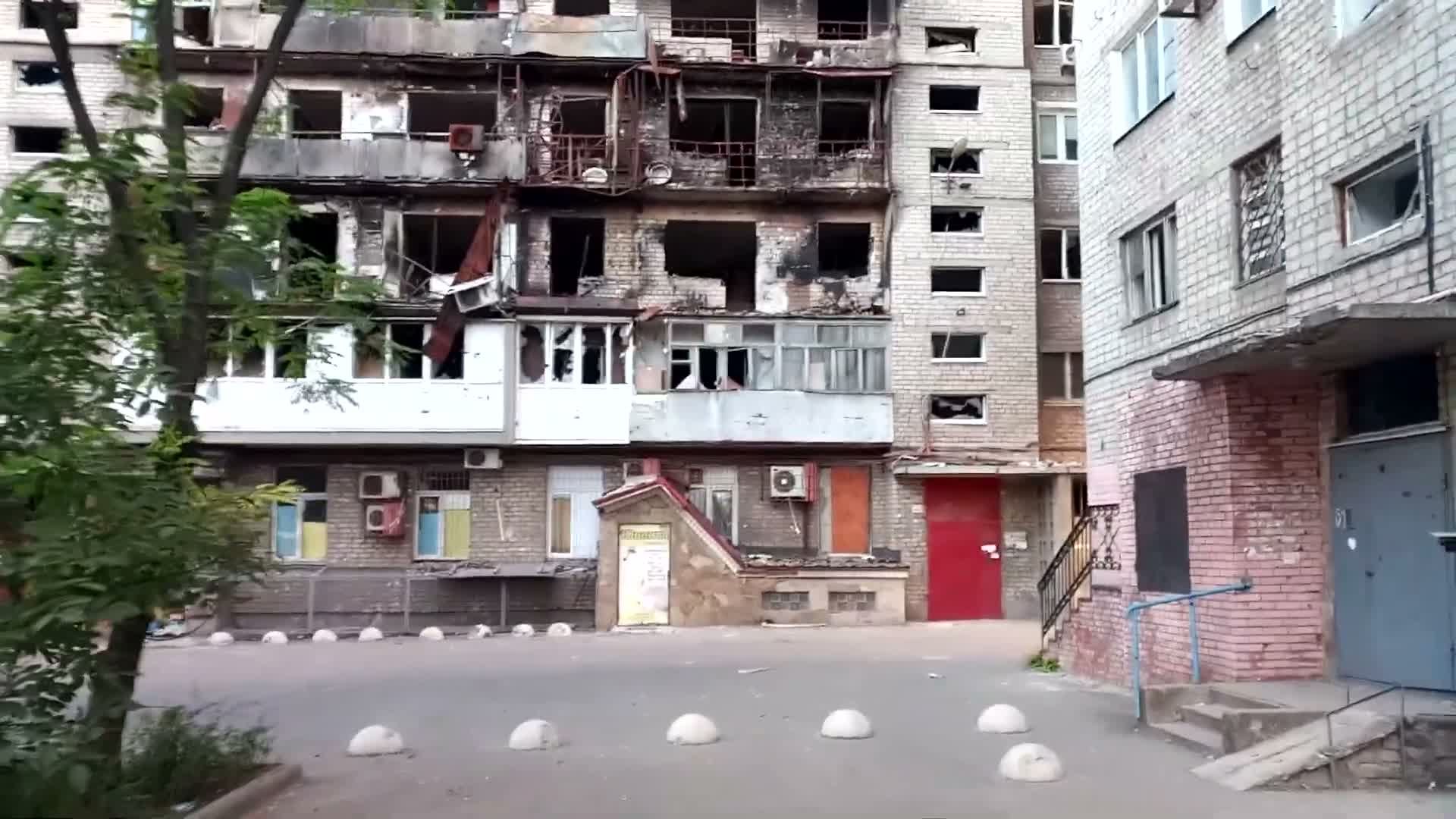 104 courtyard siege damage — burnt, blown-out balconies