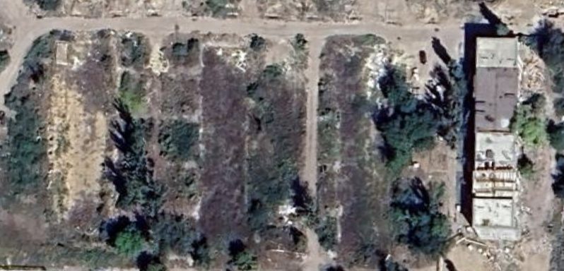 Satellite view of the same footprint in August 2024, showing the buildings demolished and the lot cleared and graded.