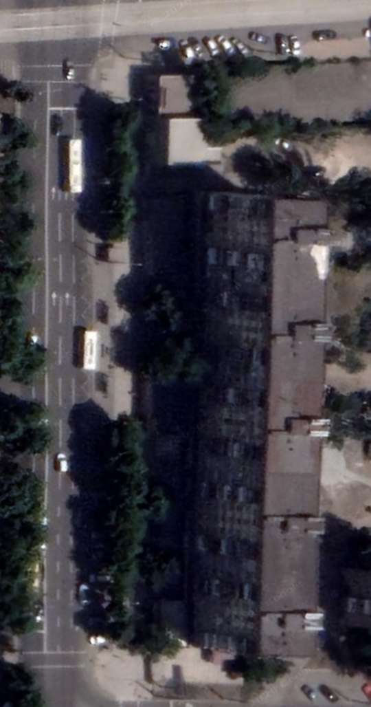 Satellite view, June 2021: the nine-story apartment block on Metallurgov Avenue 47 intact, with vehicles parked alongside and a row of street trees.